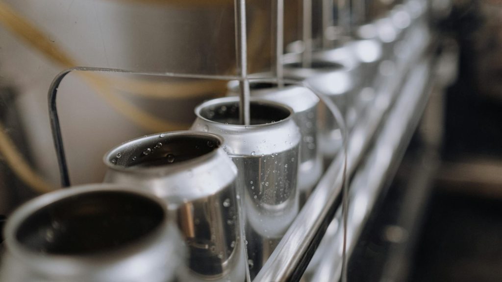 cans on a canning line being filled with beer